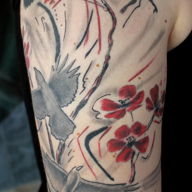 Madarak és virágok tetoválás felkaron